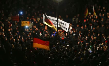 Participants hold German national flags during a demonstration called by anti-immigration group PEGIDA, a German abbreviation for "Patriotic Europeans against the Islamization of the West", in Dresden December 8, 2014. REUTERS/Hannibal Hanschke