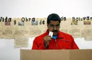 Venezuela's President Nicolas Maduro shows his ballot before casting his vote at a polling station during a legislative election, in Caracas December 6, 2015. REUTERS/Carlos Garcia Rawlins