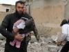 Un Syrien porte le corps d'un bébé mort après des frappes aériennes à Raga le 27 novembre 2014