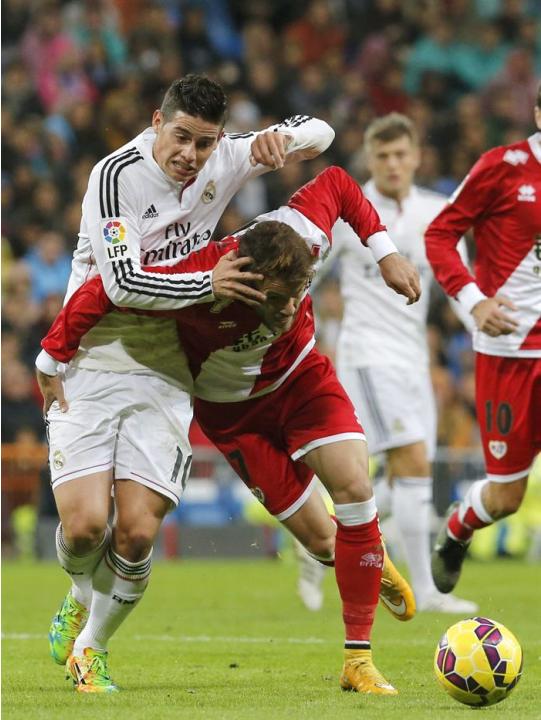 GRA322. MADRID, 08/11/2014.- El jugador colombiano del Real Madrid James Rodríguez (i) pelea un balón con Quini, del Rayo Vallecano durante el partido de la undécima jornada de Liga en Primera Divisió