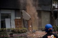 Un bombero ve caer cascotes de un edificio que demolieron tras resultar dañado por el terremoto ocurrido el pasado 8 de mayo en Ciudad de México (AFP/Archivos | Yuri Cortez)