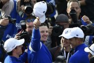 Team Europe players Rory McIlroy (L) and Justin Rose (C) celebrate teammate Jamie Donaldson winning his match against U.S. player Keegan Bradley to retain the Ryder Cup for Europe on the 15th green during their 40th Ryder Cup singles golf match at Gleneagles in Scotland September 28, 2014. REUTERS/Toby Melville