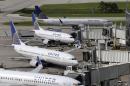 FILE - In this July 8, 2015 file photo, United Airlines planes are parked at their gates as another plane, top, taxis past them at George Bush Intercontinental Airport, in Houston. United Airlines on Friday, Oct. 23, 2015 said that it has a tentative deal to combine more than 8,600 maintenance workers from United and the former Continental Airlines under one contract, a step toward improving the carrier's rocky labor relations. (AP Photo/David J. Phillip, File)