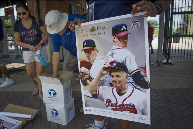 Fans collect posters commemorating the Baseball Hall of Fame induction as they enter Turner Field to view the ceremony live on the big screen and watch the Atlanta Braves take on the San Diego Padres 
