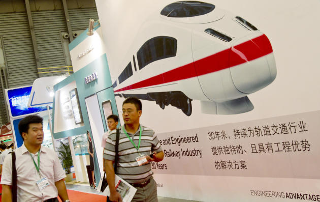 Visitantes pasan junto a un cartel que muestra un tren de alta velocidad diseñado por China Railway Construction en la Exposición Internacional de Trenes de China, el 23 de agosto de 2011 en Shangai (AFP/Archivos | Str)