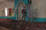 Un soldado afgano monta guardia dentro de una mezquita después de la explosión de una bomba en el distrito de Khogyani, en la provincia de Nangarhar, al este de Kabul, Afganistán, el viernes 28 de noviembre de 2014. (Foto AP)