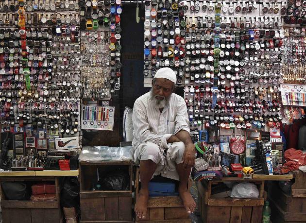 A vendor waits for customers at his shop selling wrist watches along a roadside in Kolkata