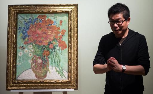 Wang Zhongjun stands next to his Vincent van Gogh 1890 still life painting 'Nature Morte, Vase Aux Marguerites et Coquelicots' (Still Life, Vase with Daisies and Poppies), at Sotheby's Hong Kong Gallery on December 6, 2014
