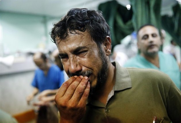 A Palestinian man cries after bringing a child, wounded in an Israeli strike on a compound housing a U.N. school in Beit Hanoun, in the northern Gaza Strip, to the emergency room room of the Kamal Adwan hospital in Beit Lahiya, Thursday, July 24, 2014. Israeli tank shells hit the compound, killing more than a dozen people and wounding dozens more who were seeking shelter from fierce clashes on the streets outside. Gaza health official Ashraf al-Kidra says the dead and injured in the school compound were among hundreds of people seeking shelter from heavy fighting in the area. (AP Photo/Lefteris Pitarakis)