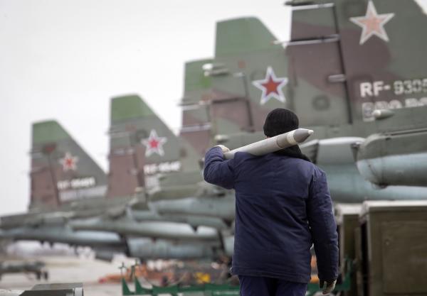 A serviceman carries a air-to-ground missile next to Sukhoi Su-25 jet fighters during a drill at the Russian southern Stavropol region, March 12, 2015. Russia has started military exercises in the country's south, as well as in Georgia's breakaway regions of South Ossetia and Abkhazia and in Crimea, annexed from Ukraine last year, news agency RIA reported on Thursday, citing Russia's Defence Ministry. REUTERS/Eduard Korniyenko (RUSSIA - Tags: POLITICS CIVIL UNREST MILITARY)