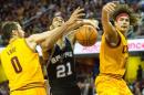 Kevin Love y Anderson Varejao, de los Cleveland Cavaliers, bloquean a Tim Duncan, de los visitantes San Antonio Spurs, en el segundo tiempo de un partido de la NBA jugado el 19 de noviembre de 2014