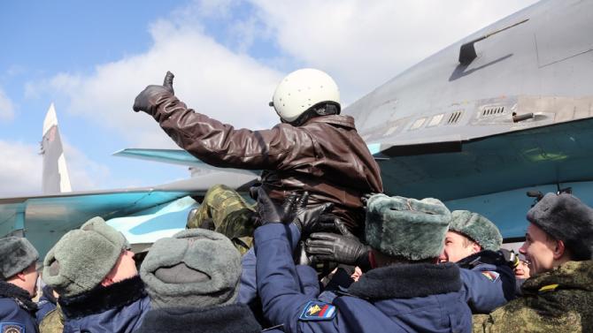 A Russian pilot is congratulated by servicemen as he returns from Syria for a ceremony at an airbase outside the city of Voronezhto, on March 15, 2016