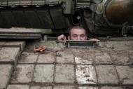 Soldado ucraniano observa de dentro de um tanque em uma base perto de Peski, região de Donetsk.