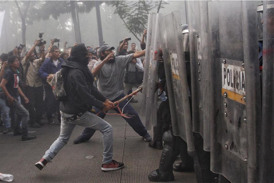 Agreden a policías tras mitin por caso Ayotzinapa