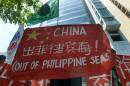 Filipino environmental activists rally outside China's consular office in Manila on May 11, 2015 against Beijing's reclamation and construction activities on islands and reefs in the Spratly islands the South China Sea