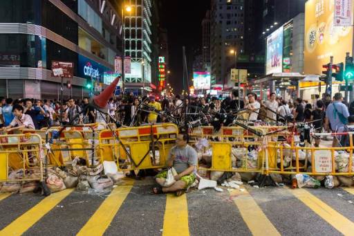 Un hombre se siente frente a una barricada construidia en el distrito de Kowloon, el 4 de octubre de 2014 por líderes estudiantiles que protestan contra el gobierno de Hong Kong