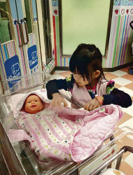 余太一家到台灣的兒童職業體驗館Baby Boss，讓幼女YY體驗投身職場，如當護士照顧嬰兒。（受訪者提供）