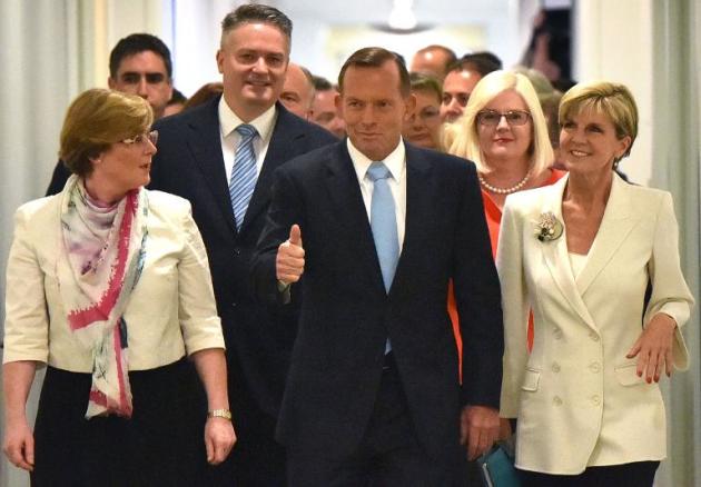 Australian Prime Minister Tony Abbott (C) walks with Foreign Minister Julie Bishop (R) to a coalition party room in Canberra on February 9, 2015 for a confidence vote on his leadership that he survived