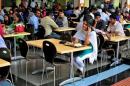 An employee speaks on a mobile phone as she eats her   lunch at the cafeteria in the Infosys campus in Bengaluru