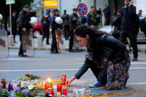People light candles in front of the riot policemen to commemorate policemen who were killed after fighting between Macedonian police and an armed group in the town of Kumanovo in Skopje on May 11, 2015