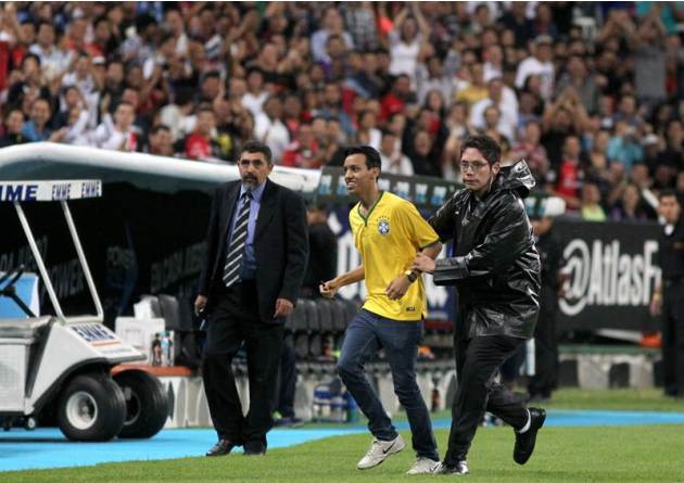MEX57. GUADALAJARA (MÉXICO), 30/09/2014.- Un aficionado es detenido tras saltar a la cancha para abordar al jugador Ronaldinho, de Querétaro, hoy, martes 30 de septiembre de 2014, durante un partido e