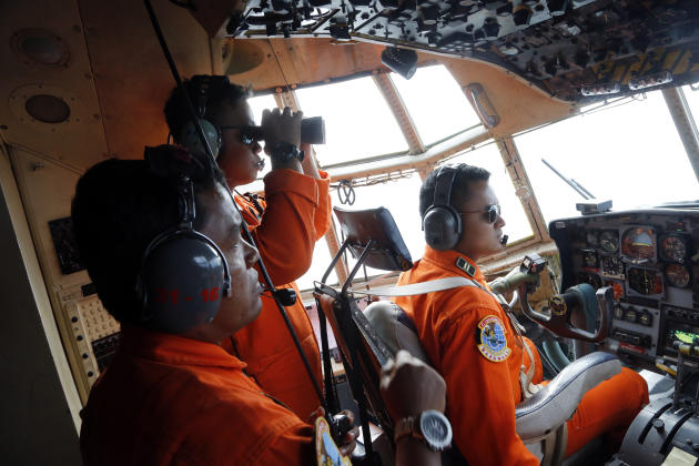 Crew of Indonesian Air Force C-130 airplane of the 31st Air Squadron scan the horizon during a search operation for the missing AirAsia flight 8501 jetliner over the waters of Karimata Strait in Indonesia, Monday, Dec. 29, 2014. Search planes and ships from several countries on Monday were scouring Indonesian waters over which the AirAsia jet disappeared, more than a day into the region's latest aviation mystery. Flight 8501 vanished Sunday in airspace thick with storm clouds on its way from Surabaya, Indonesia, to Singapore. (AP Photo/Dita Alangkara)