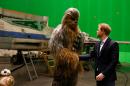 El príncipe Harry de de Gales saluda al personaje Chewbacca en el set de filmación de La guerra de las Galaxias en el estudio cinematográico Pinewood en Londres el 19 de abril de 2016