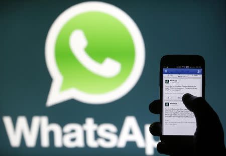 A Whatsapp App logo is seen behind a Samsung Galaxy S4 phone that is logged on to Facebook in the central Bosnian town of Zenica, February 20, 2014. REUTERS/Dado Ruvic/Files