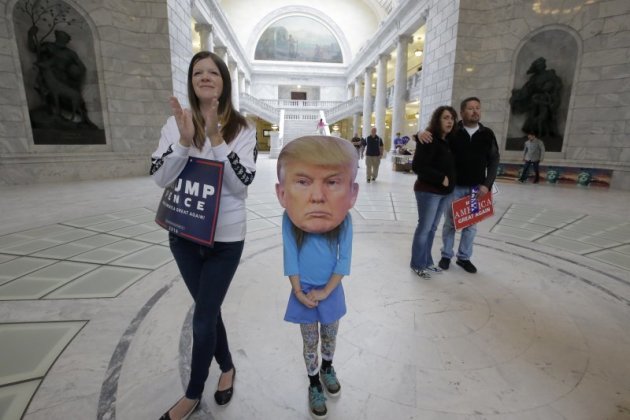 川普支持者幫自己的孩子帶上川普面具。（美聯社）