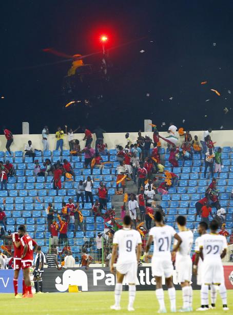 Equatorial Guinea fans react as a police helicopter hovers above the stand during the African Cup semi-final match against Ghana in Malabo
