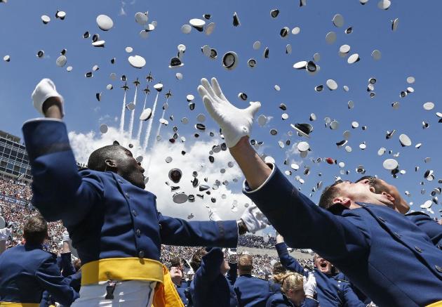 Air Force Academy graduates throw their caps into the air as F-16 jets from the Thunderbirds make a flyover, at the completion of the graduation ceremony for the class of 2014, at the U.S. Air Force A