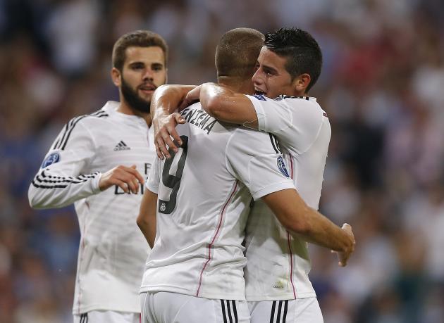 Real Madrid's Karim Benzema, centre,  celebrates with Real Madrid's James Rodriguez after scoring his side's fifth goal during the Champions League Group B soccer match between Real Madrid and Basel a