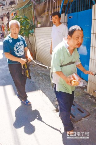 王父（左）眼睛失明，怕重度智能障礙兒子亂跑，平時用繩子將兩人相繫上街撿資源回收。（林宏聰攝）