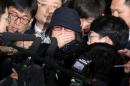 Choi Soon-sil, who is involved in a political   scandal, reacts as she is surrounded by the media upon her arrival at a   prosecutor's office in Seoul