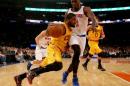 Kyrie Irving de los Cavaliers de Cleveland se lleva el balón marcado por Samuel Dalembert de los Knicks de Nueva York el 4 de diciembre de 2014