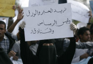 Un estudiante alza un cartel con la leyenda en árabe "queremos tinta y lapiceras, no balas y fusiles", en una protesta contra la insurgencia chií en la Universidad de Sana, Yemen, 25 de noviembre de 2014. (AP Foto/Hani Mohammed)