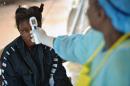Une jeune fille possiblement porteuse du virus Ebola à un contrôle de température à l'hôpital de Kenema en Sierra Leone le 16 août 2014