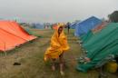 Varios nepalíes caminan bajo la lluvia en un campamento para los supervivientes del terremoto que azotó Nepal en abril, en Katmandú el 23 de mayo de 2015