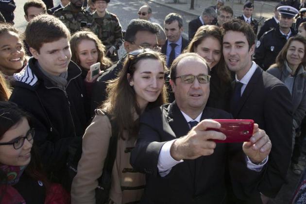 O presidente francês François Hollande participa de cerimônia em 11 de novembro de 2014 e tira 'selfies' com estudantes, em Paris