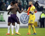 Everton's Sylvain Distin, scorer Romelu Lukaku and goalkeeper Tim Howard, from left, celebrate after the Europa League Group H soccer match between VfL Wolfsburg and Everton FC at the Volkswagen Arena stadium in Wolfsburg, Germany, Thursday, Nov. 27, 2014. Everton defeated Wolfsburg by 2-0. (AP Photo/Michael Sohn)
