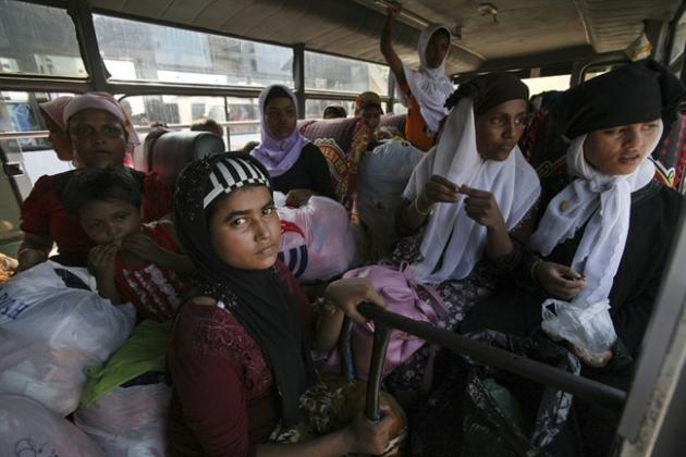 Ethnic Rohingya women sit inside a bus as they are transferred from a sports stadium to another temporary shelter for the migrants whose boats were washed ashore on Sumatra island on Sunday, in Lhoksukon, Aceh province, Indonesia, Wednesday, May 13, 2015. More than 1,600 migrants and refugees have landed on the shores of Malaysia and Indonesia in the past week and thousands more are believed to have been abandoned at sea, floating on boats with little or no food after traffickers literally jumped ship fearing a crackdown. (AP Photo/Binsar Bakkara)