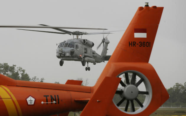 A U.S. Navy helicopter approaches to land following their search operation for the victims of AirAsia Flight 8501at the airport in Pangkalan Bun, Indonesia, Tuesday, Jan. 6, 2015. The search operation for AirAsia Flight 8501 will spread slightly eastward on Tuesday as the weather and currents drag wreckage in that direction, the head of Indonesia's rescue agency said. (AP Photo/Achmad Ibrahim)