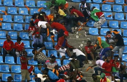 Equatorial Guinea fans react as a police helicopter hovers over after some of them threw objects during their African Nations Cup semi-final soccer match against Ghana in Malabo