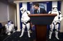 White House press secretary Earnest and Star Wars Stormtroopers wait for Star Wars Robot R2-D2 to enter the briefing room after U.S. President Obama finished his end of the year news conference at the White House in Washington