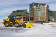 Una motoniveladora retira la nieve del estacionamiento del Lambeau Field en Green Bay, Wisconsin, el martes 6 de enero de 2015. El domingo 11, los Packers se enfrentan ahí a los Cowboys de Dallas en la postemporada (AP Foto/Mike Roemer)