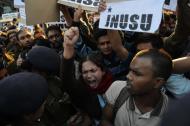 Indian residents hold placards and chant slogans as they take part in a protest against the alleged rape of a passenger by a driver working for the Uber taxi company in New Delhi on December 7, 2014