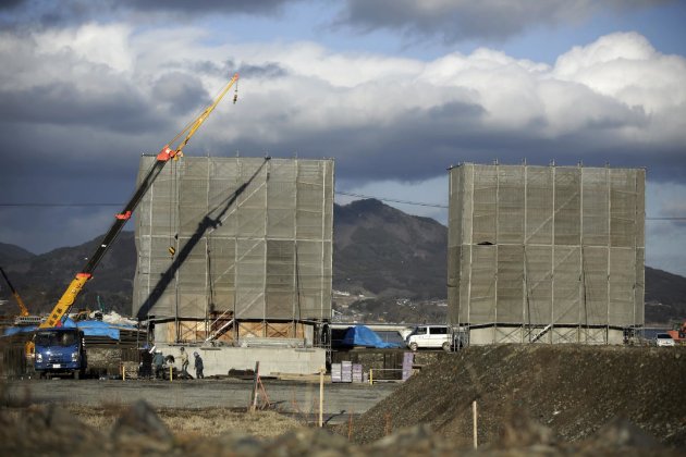 Obreros trabajan en la construcción de un gigantesco muro de cemento para proteger la costa de un tsunami en Rikuzentakata, localidad del noreste de Japón, el 5 de marzo del 2015. (AP Photo/Eugene Hoshiko)