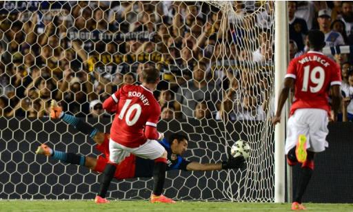 Manchester United's Wayne Rooney scores from the penalty spot as LA Galaxy goalkeeper Brian Perak attempts a save during their in Pasadena, California on July 23, 2014