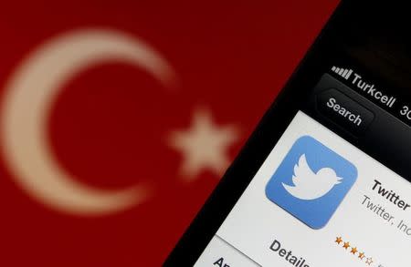 A Twitter logo on an iPhone display is pictured next to a Turkish flag in this photo illustration taken in Istanbul March 21, 2014. REUTERS/Murad Sezer/Files