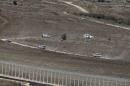 U.N. vehicles drive in Syria near the border fence   with the Israeli-occupied Golan Heights